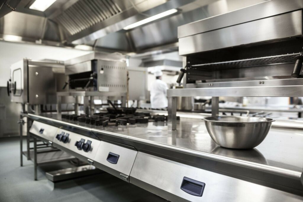 a clean commercial kitchen with stainless steel pots, pans, and appliances